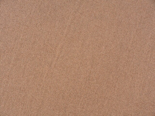 Fototapeta na wymiar Sandy background. Wet sea sand.