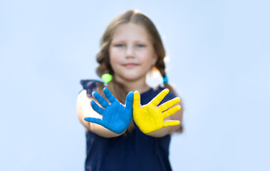 Happy girl showing painted hand palms in yellow and blue. Independence, flag. constitution day of...