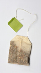Teabag with green label on light grey background