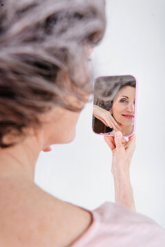 Portrait of mature woman looking at mirrow