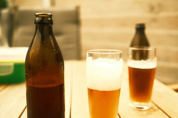 Bierflaschen und Biergläser auf einem Tisch im Garten