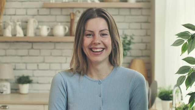 Laughing happy blonde smiling women looking at camera. Closeup girls kind emotions. Sincere eyes with open neck. Indoors american housewife. Natural beaty hair. Charm look.