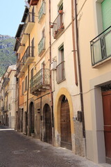 Fototapeta na wymiar Antrodoco Street View with House Facades, Arched Doors and Iron Balconies, Central Italy