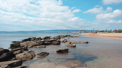 Mound of large stones on the beach. Cobblestones on the sandy shore of the Black Sea in the Crimea. Crimean coast