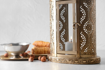Muslim lantern with Turkish sweets on light background