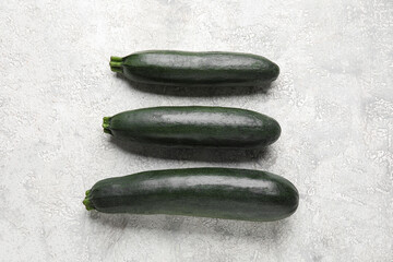 Fresh zucchini squashes on light background