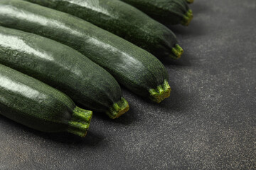 Fresh zucchini squashes on dark background, closeup