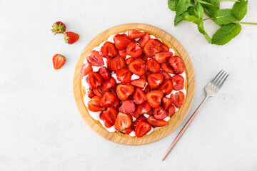 Wooden board with tasty strawberry pie on light background