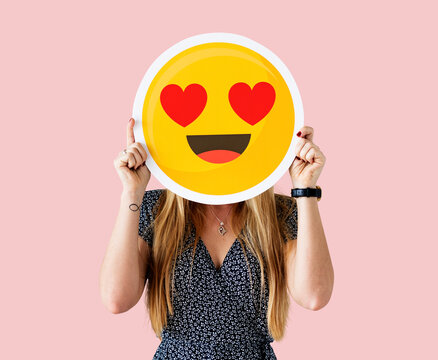 Cheerful woman holding emoticon icon - Powered by Adobe