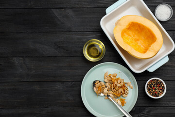 Raw spaghetti squash half in baking dish with seeds and spices on dark wooden table, flat lay. Space for text