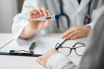 Close up of doctor using digital thermometer examination fever and diagnose disease with a patient in an examination room at a hospital, Medical and Health Care Concept. - Powered by Adobe