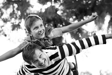 Superhero boy flying on the back of his dad