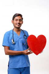 Young male doctor holding a beautiful red heart shape in hand