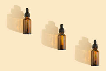 Bottles of dark amber glass with essential, lotion, serum on a beige background. Natural SPA organic cosmetic. Layout of the beauty salon branding. Flat lay, top view.