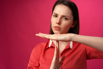 Young attractive woman showing a rejection gesture on a pink background