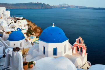 Famous view from viewpoint of Santorini Oia village with blue dome of greek orthodox Christian...