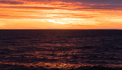 beautiful spring sunset by the sea. orange textured sky. wild beach.