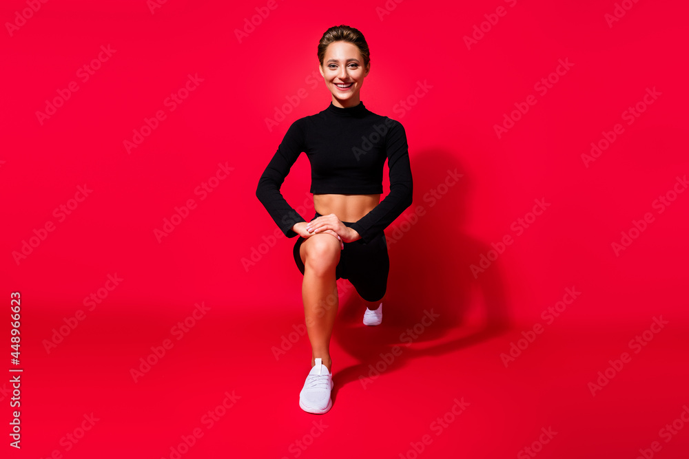 Poster Portrait of attractive cheerful endurant strong girl doing sit ups crossfit isolated over bright red color background