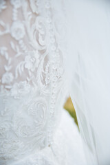 Obraz na płótnie Canvas Gentle picture of a bride standing from behind. Close up of bride dress. White lace dress.