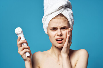 woman with towel on head naked shoulders massager cosmetology skin care