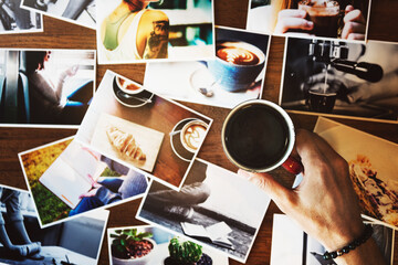 Hand holding coffee cup with may photograph on the table