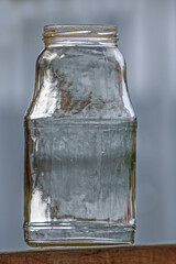 Empty glass bottle on a wooden surface close-up