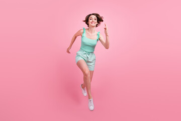 Fototapeta na wymiar Full length body size view of attractive cheerful girl jumping running fast isolated over pink pastel color background