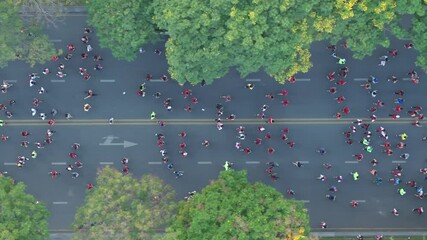 Aerial top shot of many runners running on the street at night of Ho Chi Minh City, Vietnam
