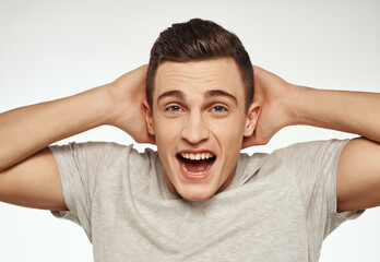 smiling man in light t-shirt gesturing with hands emotions cropped view studio