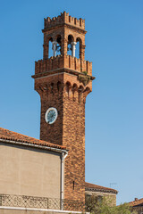 Fototapeta premium Close-up of the ancient Civic Tower or Clock Tower in Murano island in medieval style. Campo Santo Stefano (Saint Stephen square), Venice, UNESCO world heritage site, Veneto, Italy, Europe. 