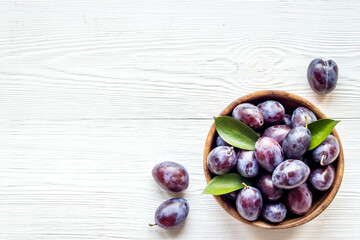 Purple plums in bowl. Plum harvest top view