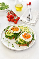 Fried eggs, avocado and greens on toasted bread