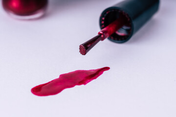 Close up of brilliant nail polish on isolated white background. Bright red lacquer for manicure