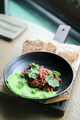 Traditional steak tartare with green hummus