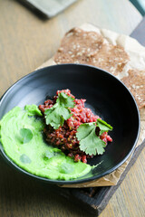Traditional steak tartare with green hummus