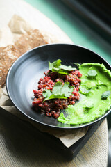 Traditional steak tartare with green hummus