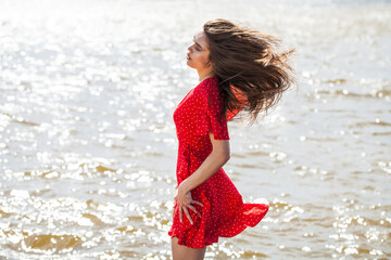 Fototapeta premium Portrait of a young beautiful woman in red dress