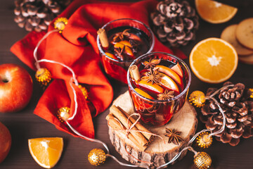 Mulled wine on table with Christmas lights and red napkin, cozy winter still life. Winter lifestyle at home, winter drink closeup, warm atmosphere