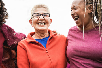 Multiracial senior women having fun together after sport workout outdoor - Focus on center woman...