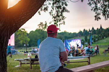 Summer cinema. A man watching a movie in the open air
