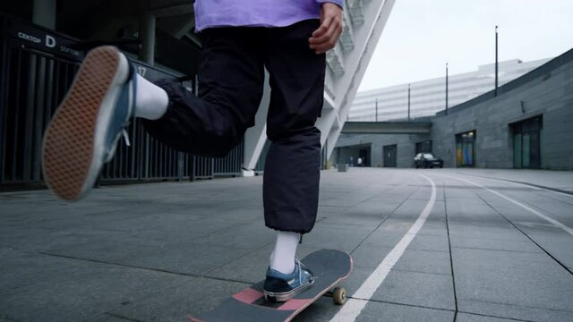 Young man using skateboard outdoor. Stylish hipster balancing on board outside.