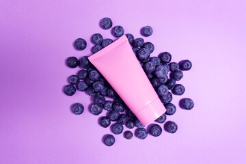 Creative beauty fashion concept photo of cosmetic recyclable bottle lotion cream with blueberry on...