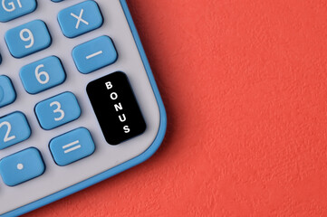 Top view of calculator with text BONUS isolated on red background