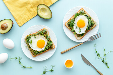 Open sandwich with eggs and avocado on plate. Overhead view