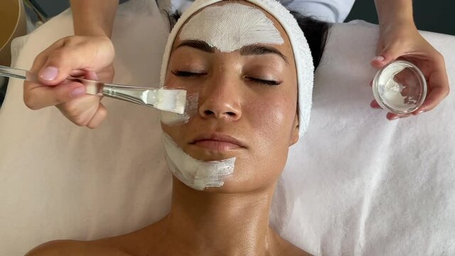 applying cream to the face in a beauty salon. skin care