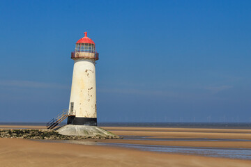 Fototapeta na wymiar Old lighthouse on the sandy shore. Point of Air, Wales.