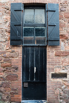 Black Painted Wooden Storm Shutters Over A Victorian Warehouse Window