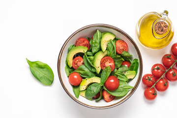 Avocado spinach salad on white plate. Healthy food in a bowl. Top view, copy space