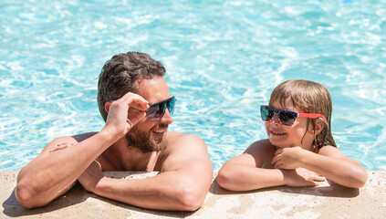 childhood and parenting. friendship. father and son wear glasses in swimming pool water