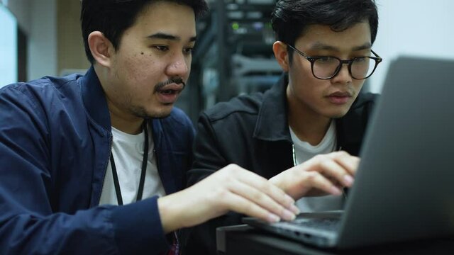 slow motion scene senior programmer hand teach employee trainee on keyboard laptop to input code language into software system during suggest at office for educational technology